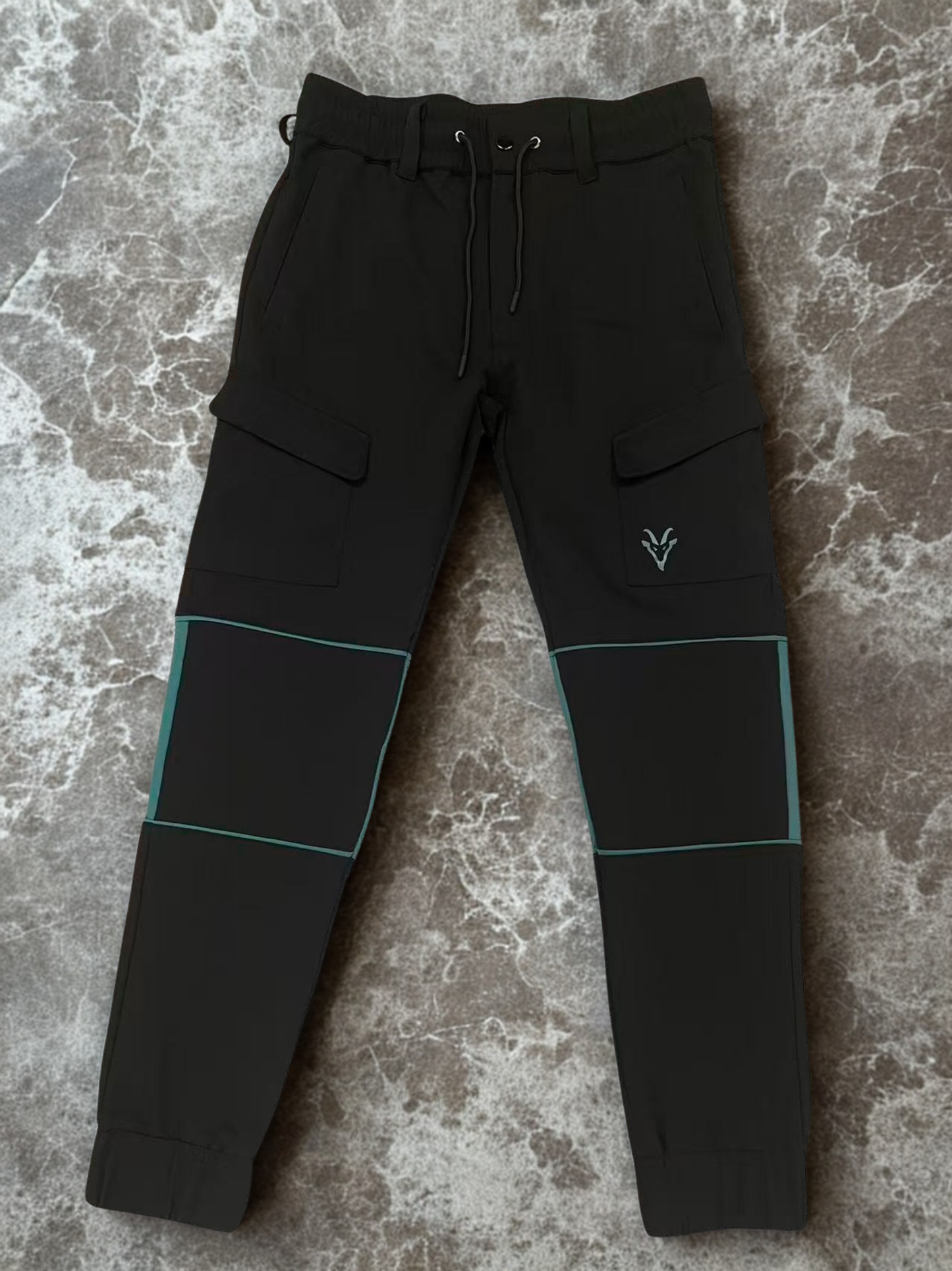 Black cargo pants with teal accents on a textured surface