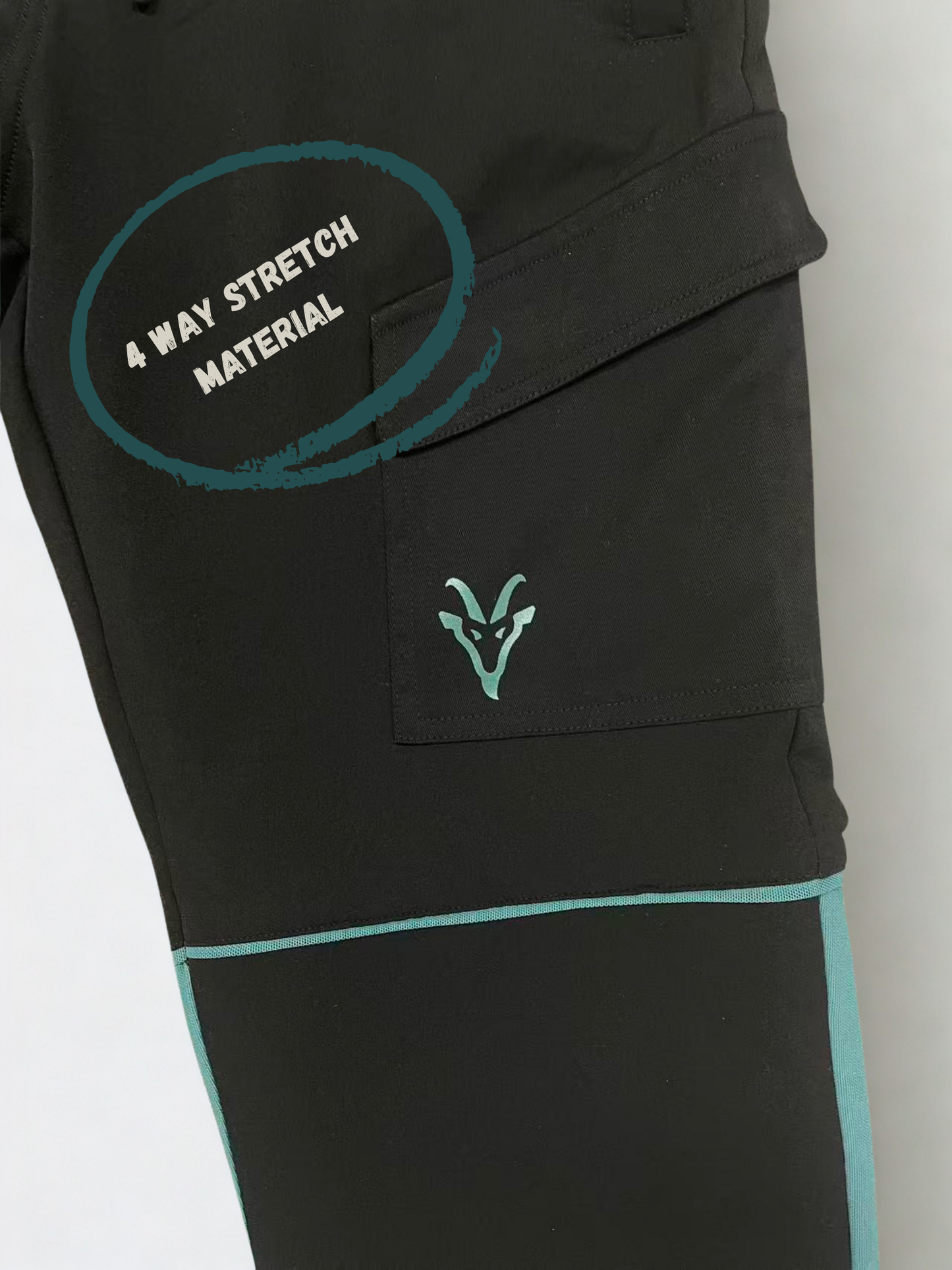 Close up of construction trousers with teal accents and a brand logo on a light gray background