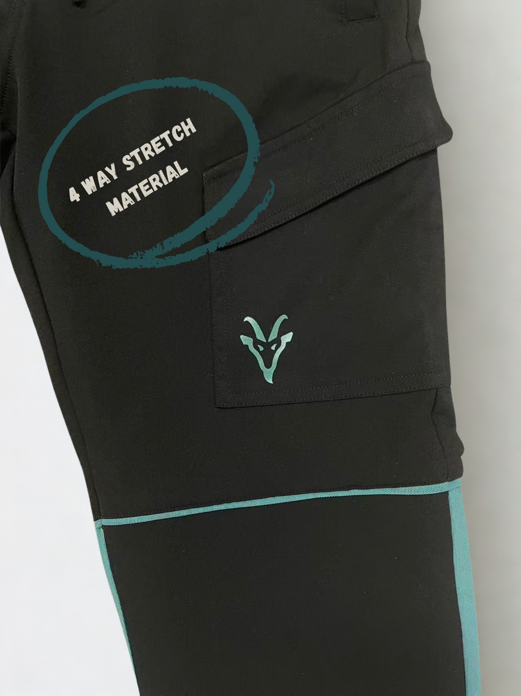 Close up of construction trousers with teal accents and a brand logo on a light gray background